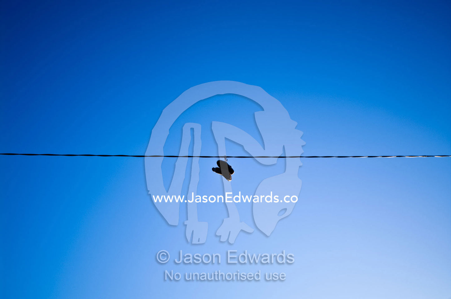 A pair of shoes hang from an electricity cable thrown there as a prank Carlton North, Victoria, Australia