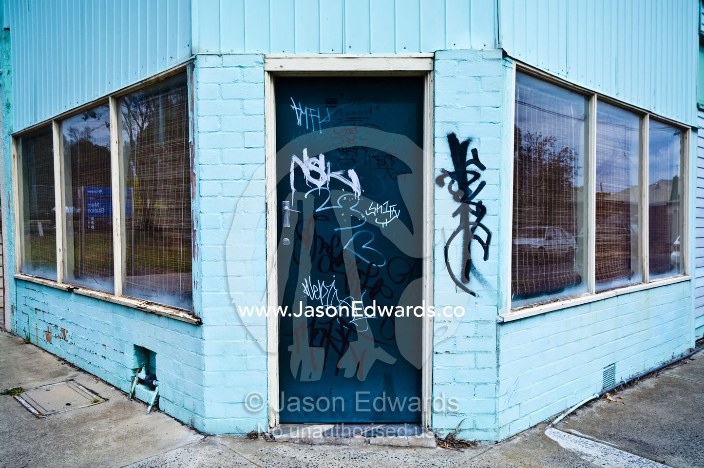 Graffiti on an old corner store painted blue and turned into a house. Fitzroy North, Victoria, Australia