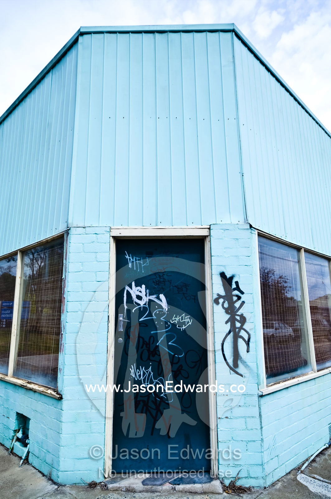 Graffiti on an old corner store painted blue and turned into a house. Fitzroy North, Victoria, Australia