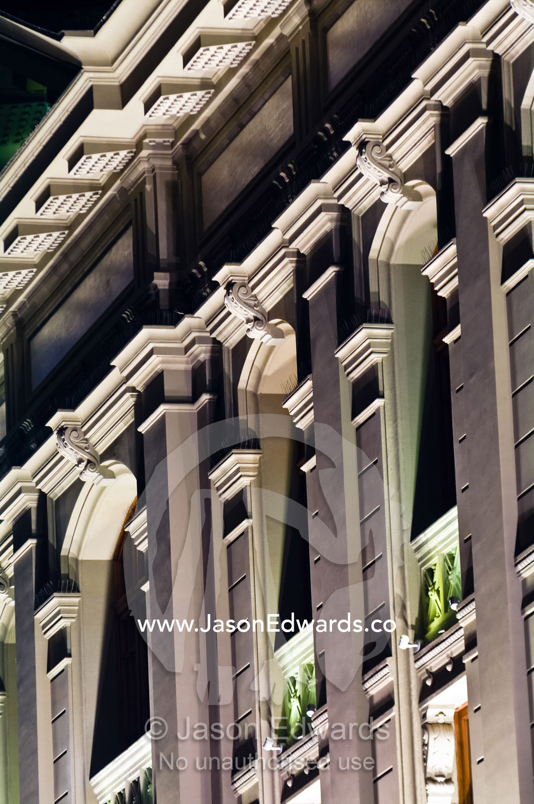 An ornate neo-classical facade etched in deep relief by street lights. Ministerio de Justicia, Santiago, Chile