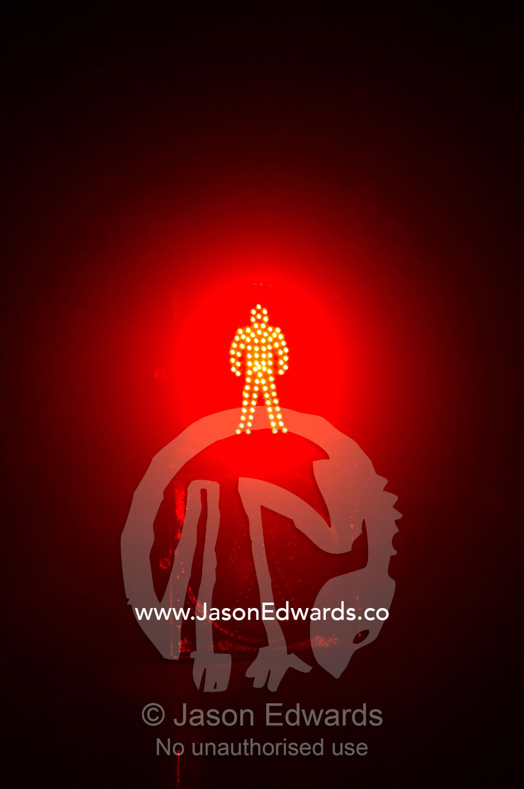 The red figure of a man at a pedestrian crossing light signals a halt. Civic District, Santiago, Chile