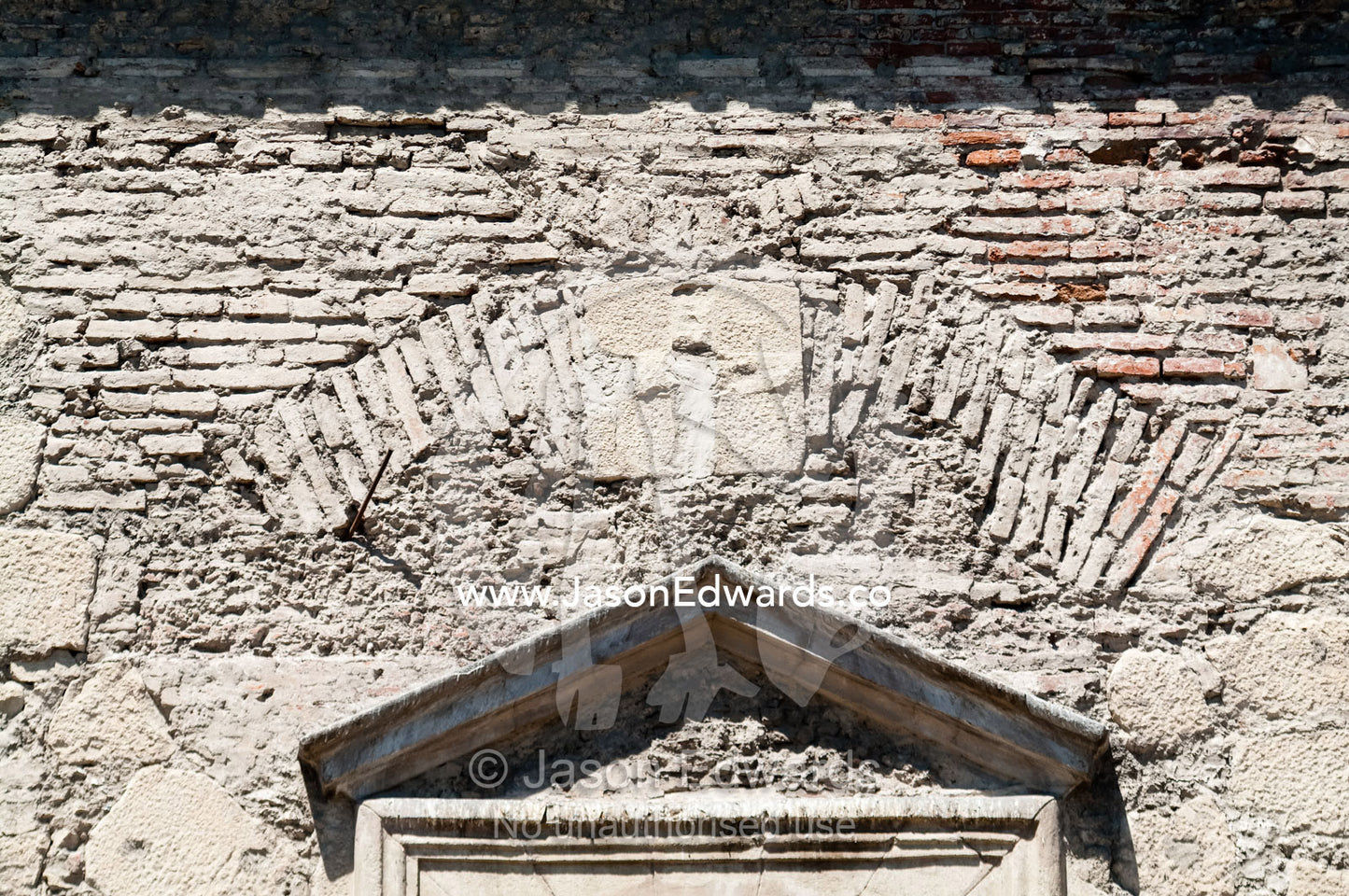 The stone wall and brick window arch to an ancient Christian church. Iglesia San Francisco, Santiago, Chile