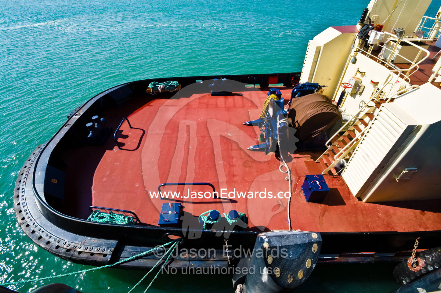 The large rear deck and winch of a tug boat moored at a marina. Darwin Waterfront, Darwin, Northern Territory, Australia