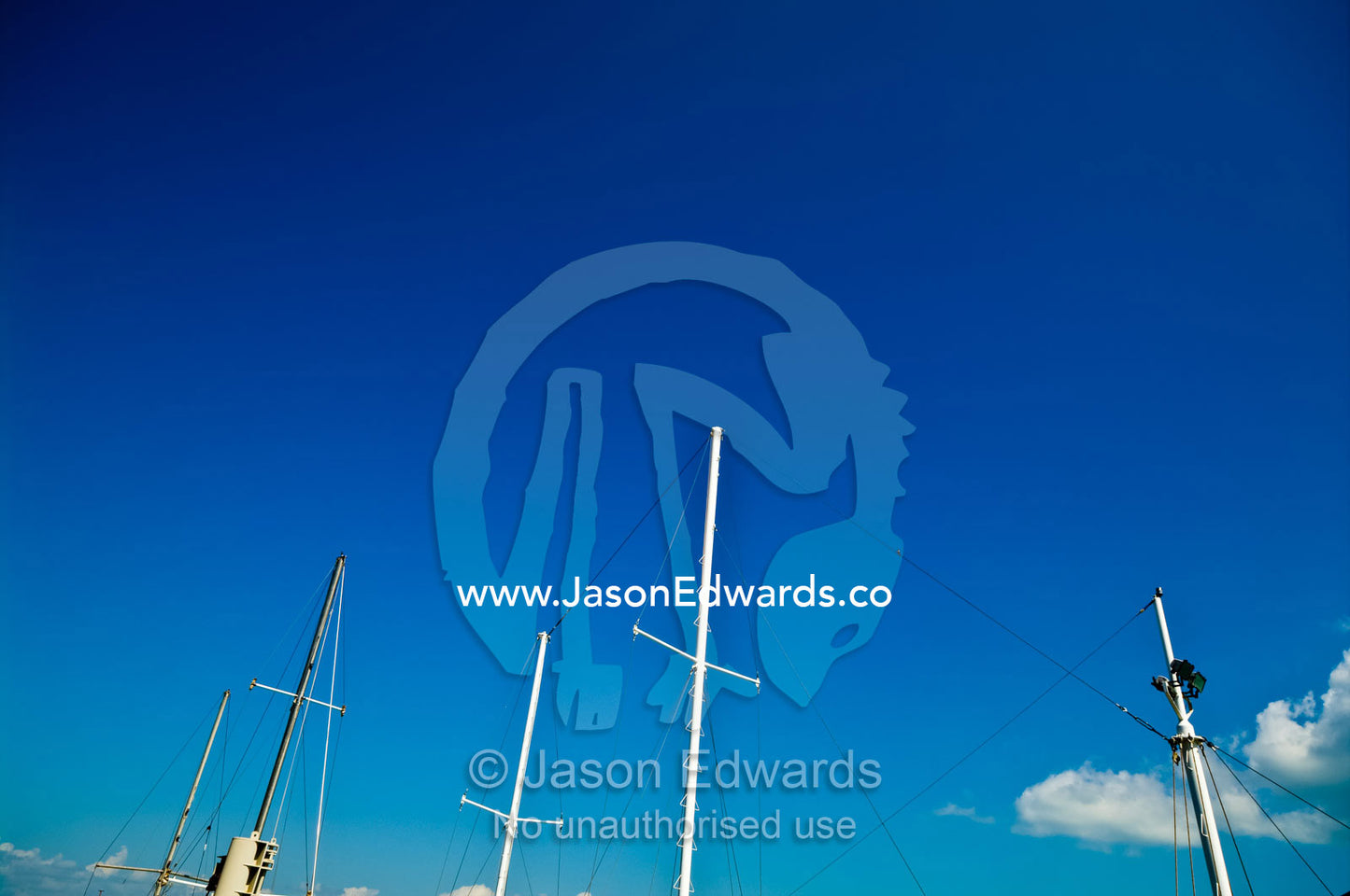 Masts with their sails lowered reach into a clear tropical blue sky. Darwin Waterfront, Darwin, Northern Territory, Australia