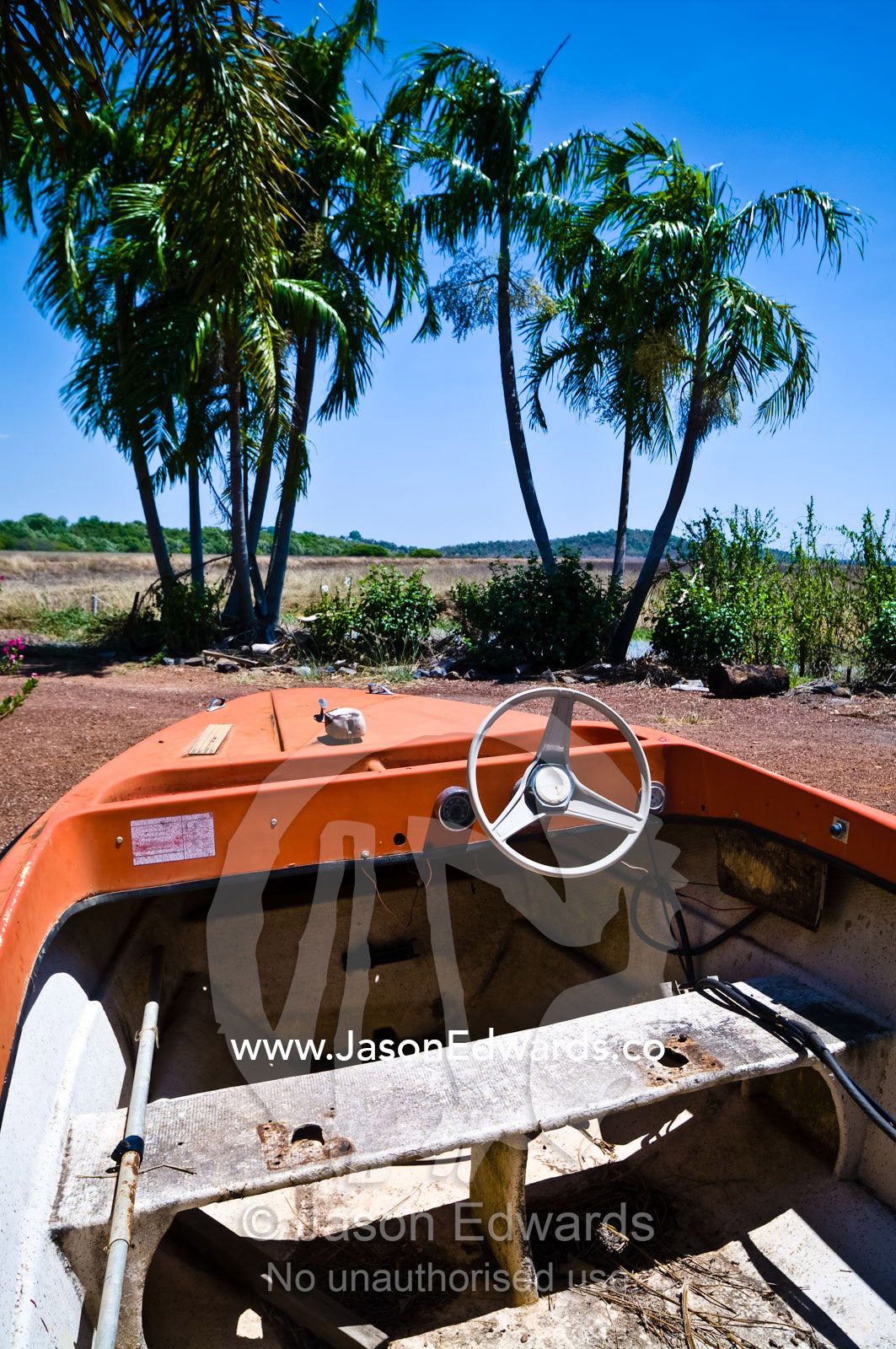A faded old, weathered and beaten motor boat resting on dry land. Alligator River, Northern Territory, Australia