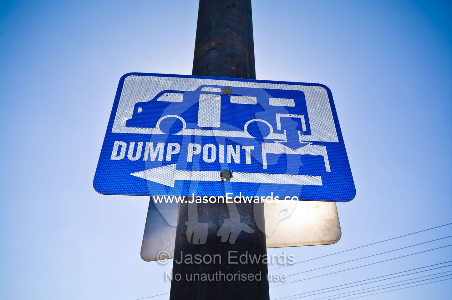 A sign mounted on a light pole directs to the local rubbish dump. Pine Creek, Northern Territory, Australia