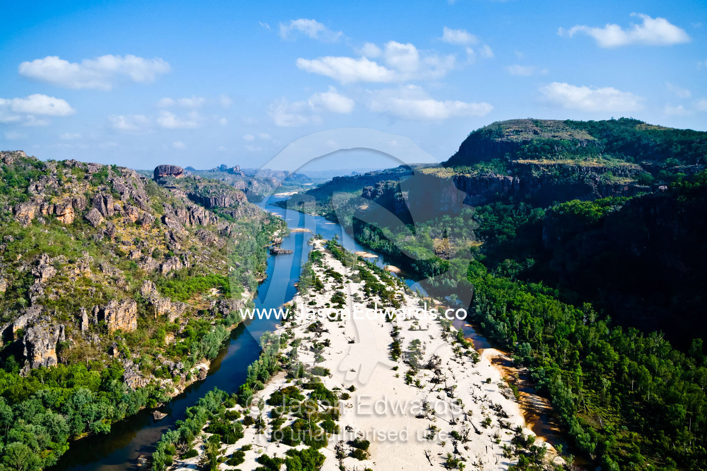 A river forks around a sand island in a rugged escarpment gorge. East Alligator River, Arnhem Land Border, Kakadu National Park, Northern Territory, Australia.