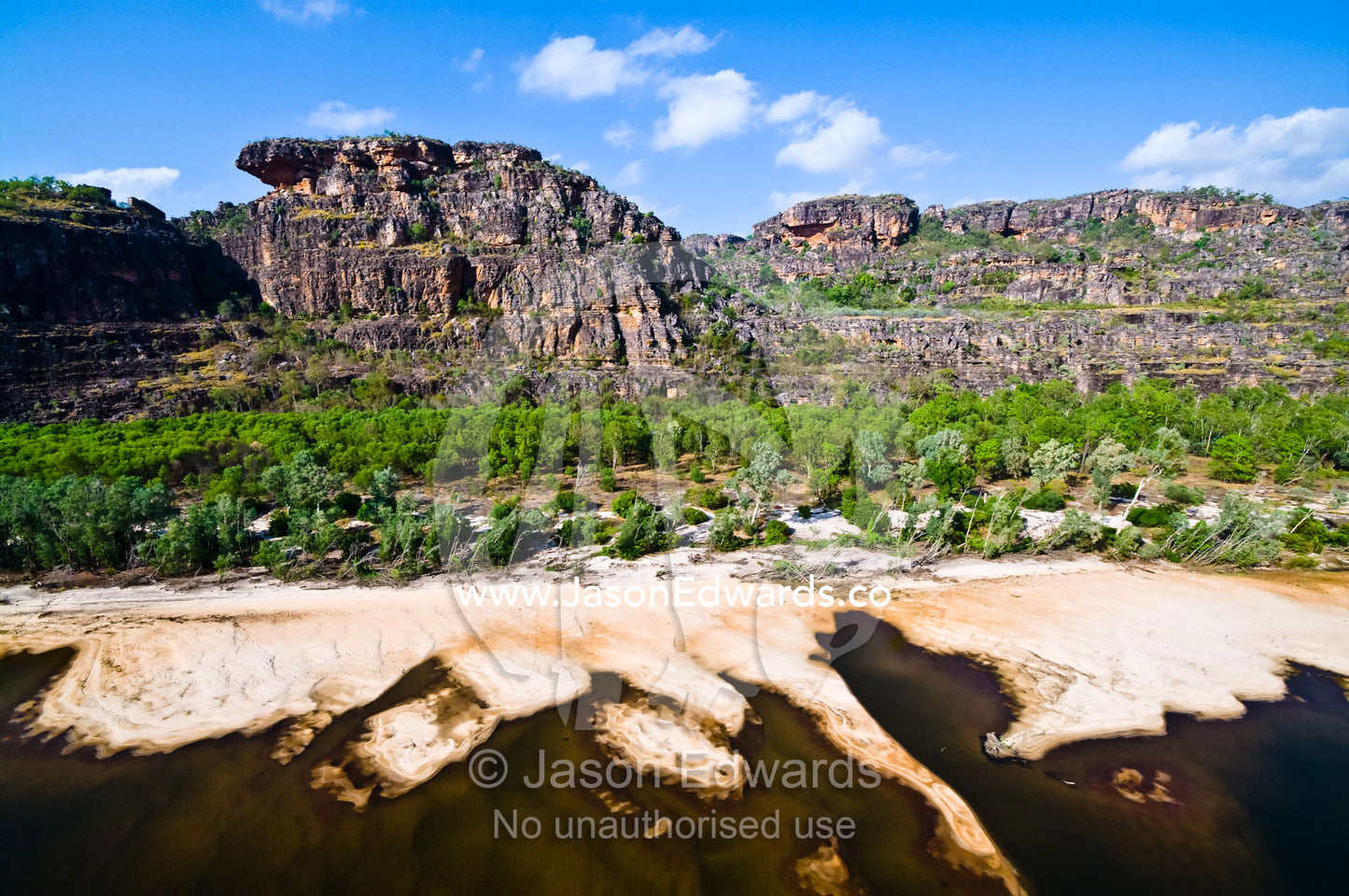 Sandbanks created by flooding Top End rivers build up beneath cliffs. East Alligator River, Arnhem Land Border, Kakadu National Park, Northern Territory, Australia.