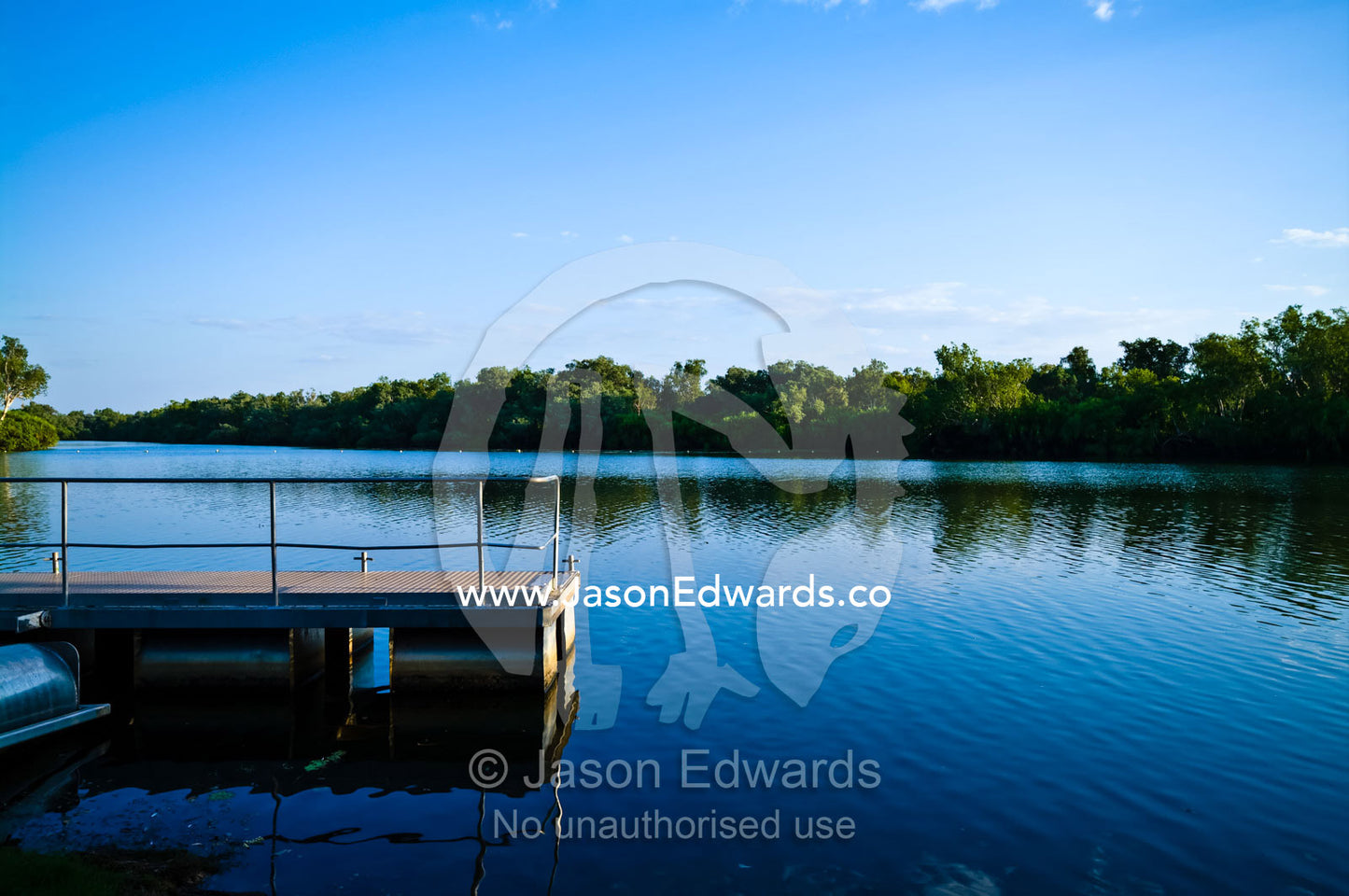 A floating pontoon rests on the calm waters of a wetland at sunset. Home Billabong, Yellow Water, South Alligator River floodplain, Kakadu National Park, Northern Territory, Australia.