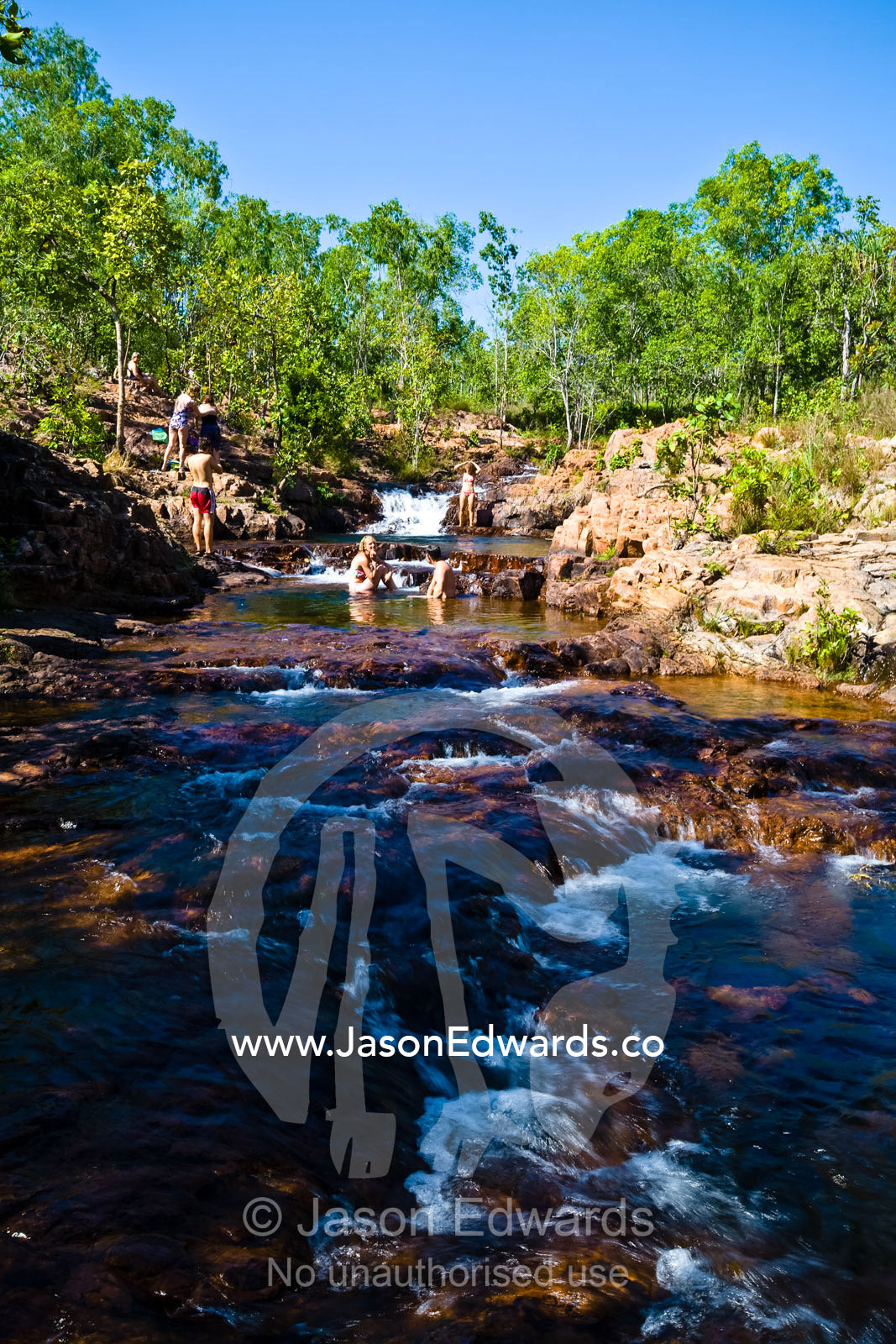 Tourists swim and cool off in pristine waterfalls and plunge pools. Buley Rockhole, Litchfield National Park, Northern Territory, Australia.