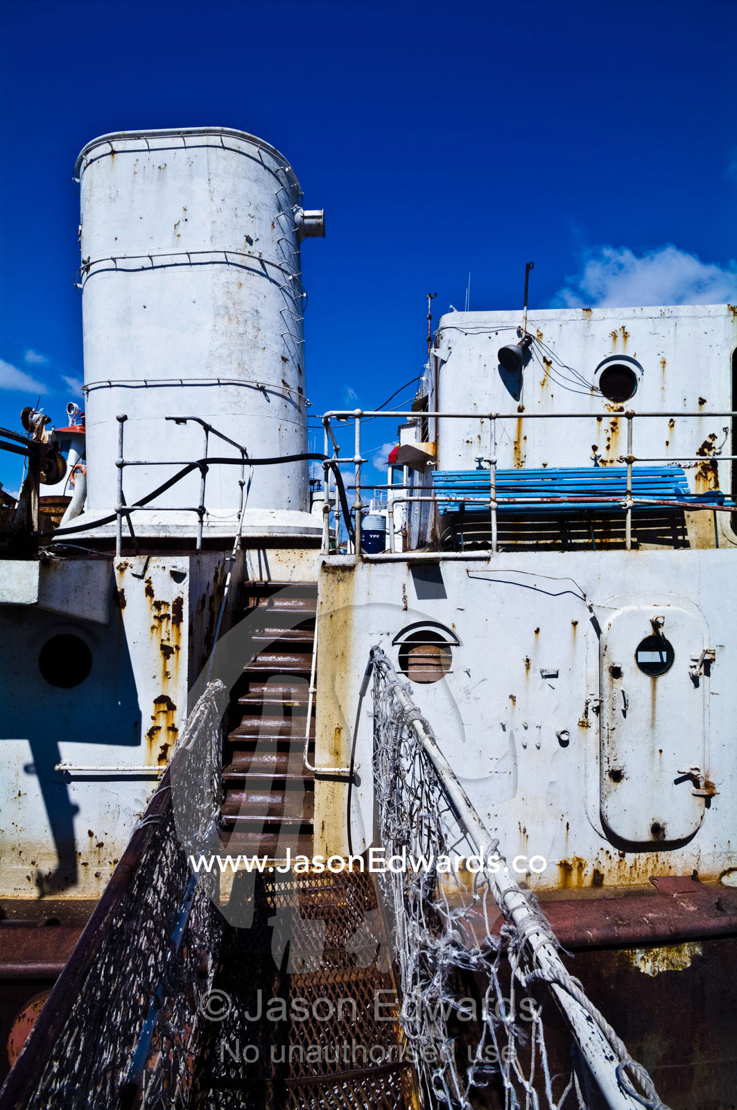 A rickety gangplank leads to the rusting deck of an old river boat. La Riachuelo, Little River, La Boca, Buenos Aires, Argentina.
