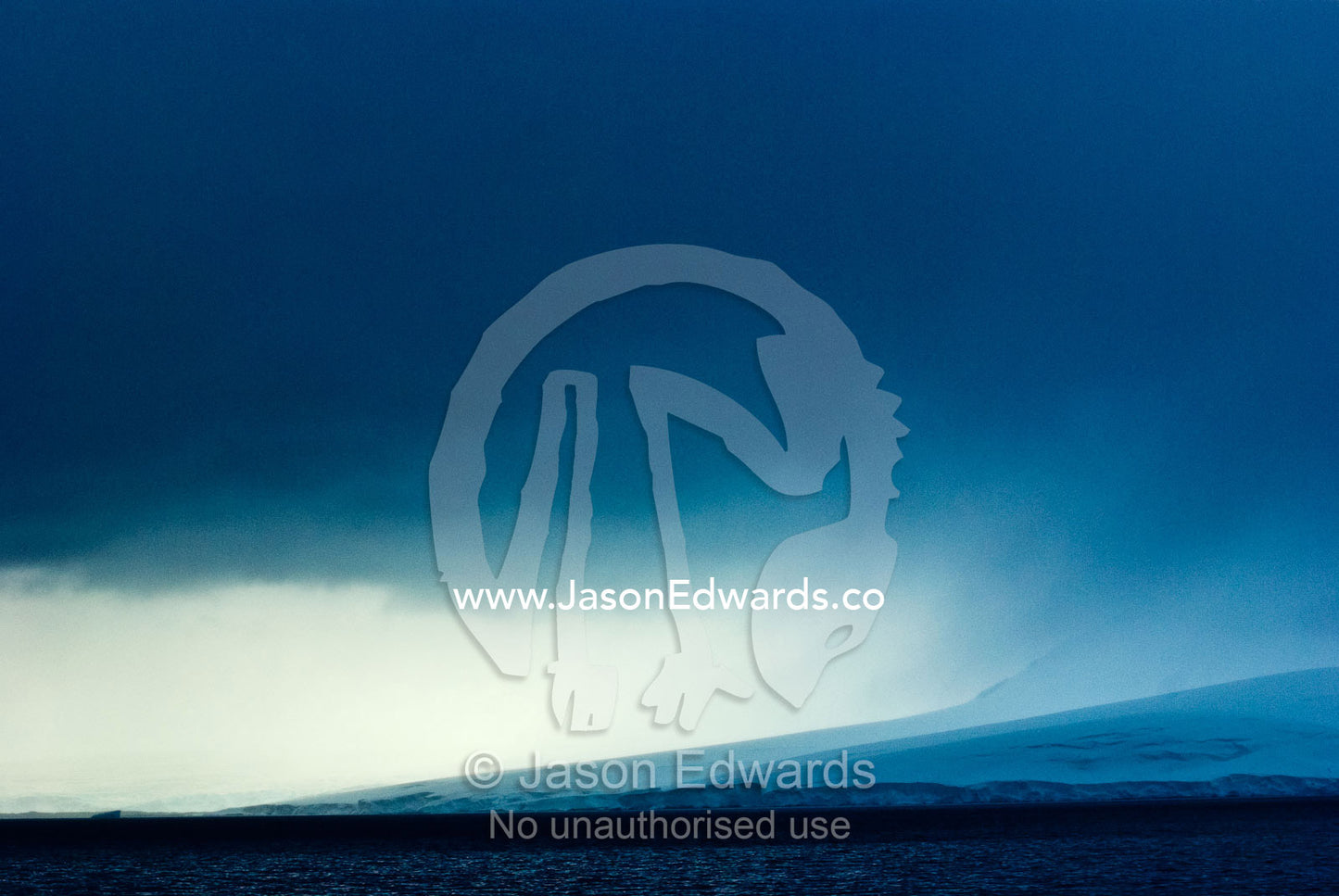 A menacing storm descends over a massive glacier running into the sea. Port Lockroy, Gerlache Strait, Antarctic Peninsula, Antarctica.