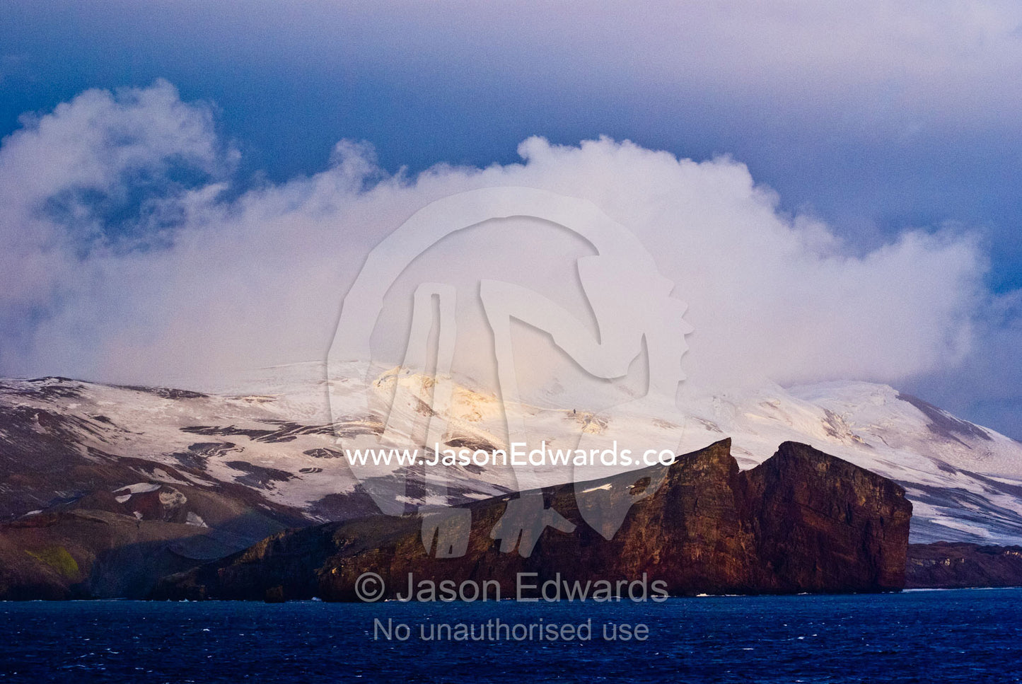 Rugged snow and ice encrusted mountain surrounding a volcanic caldera. Bransfield Strait, Deception Island, South Shetland Islands, Antarctic Peninsula, Antarctica.
