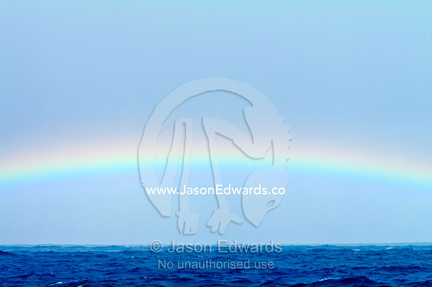 A rainbow stretches across the horizon of a vast blue tropical sea. Vava'u Island Group, Pacific Ocean, Oceania, Kingdom of Tonga.