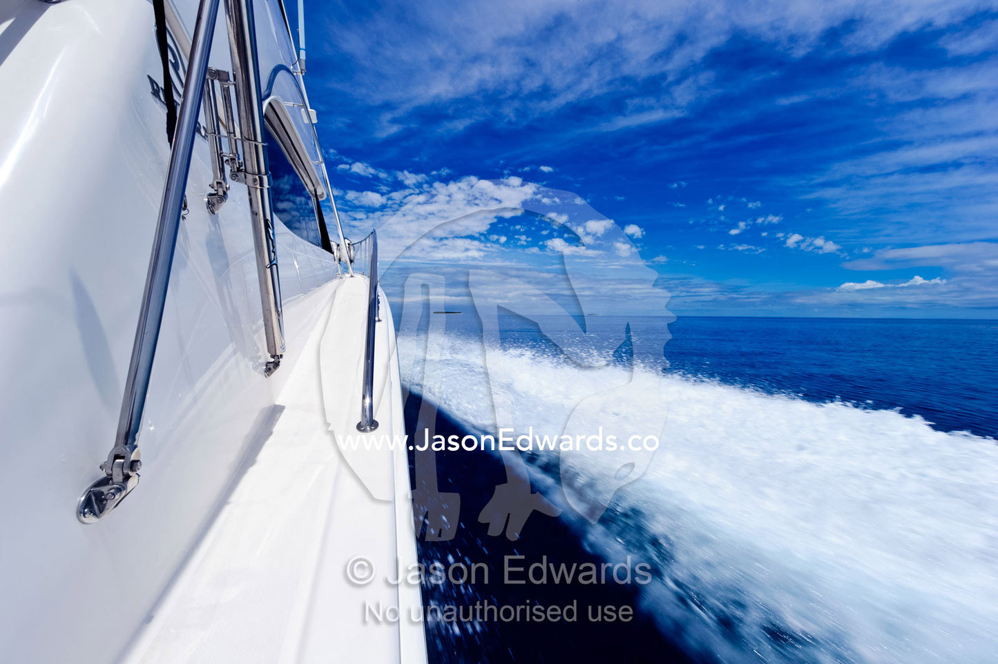 A luxury boat ploughs through a calm turquoise ocean in the Pacific. Nanuya Balavu Island, Yasawa Group, Pacific Ocean, Fiji Islands.