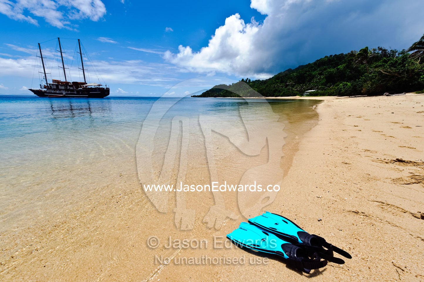 Snorkelers fins on the deserted beach of a pristine tropical island. Tabiang Village, Rabi Island, Somosomo Strait, Pacific Ocean, Fiji Islands.