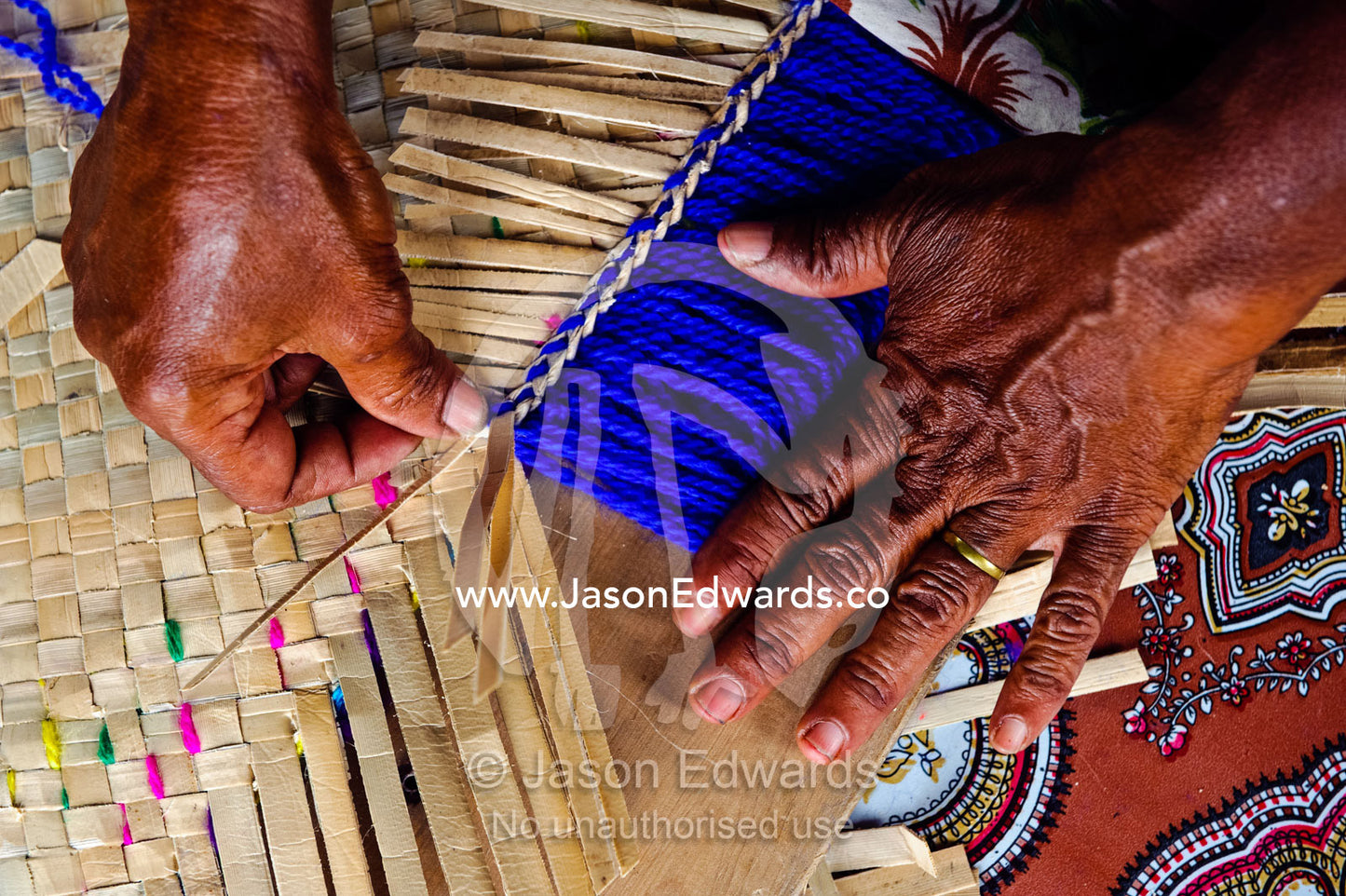 A lady hand-weaving a mat from banana leaves to go on the floor. Waitabu Marine Park, Taveuni Island, Pacific Ocean, Fiji Islands.