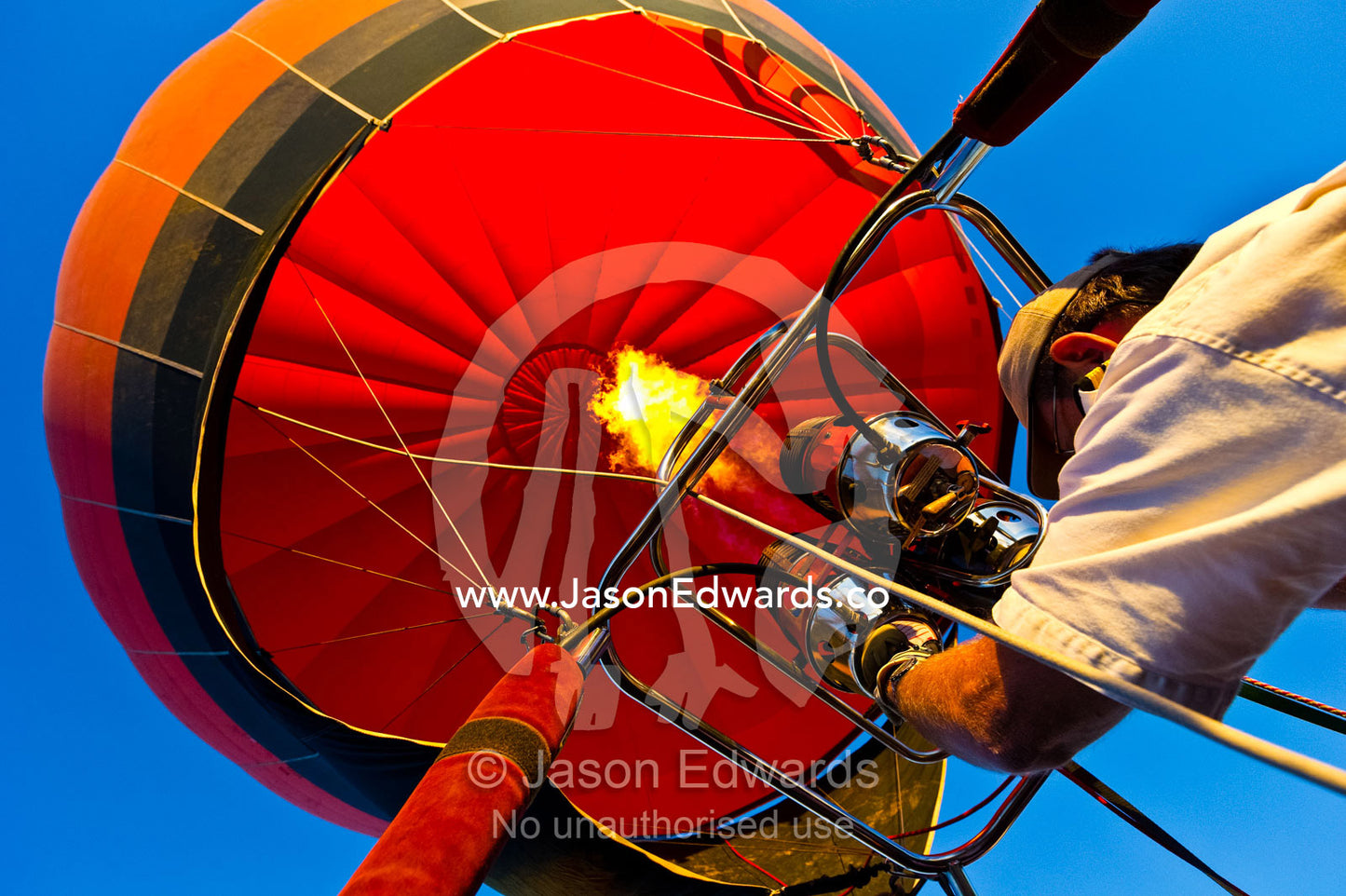A pilot of a balloon controls altitude using hot air from burning gas. Viti Levu, Pacific Ocean, Fiji Islands.