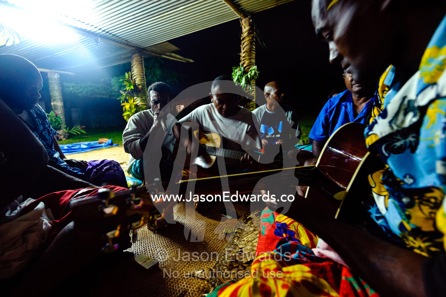 Villages play guitars and sing following a traditional kava ceremony. Wiwi Village, Taveuni Island, Pacific Ocean, Fiji Islands.