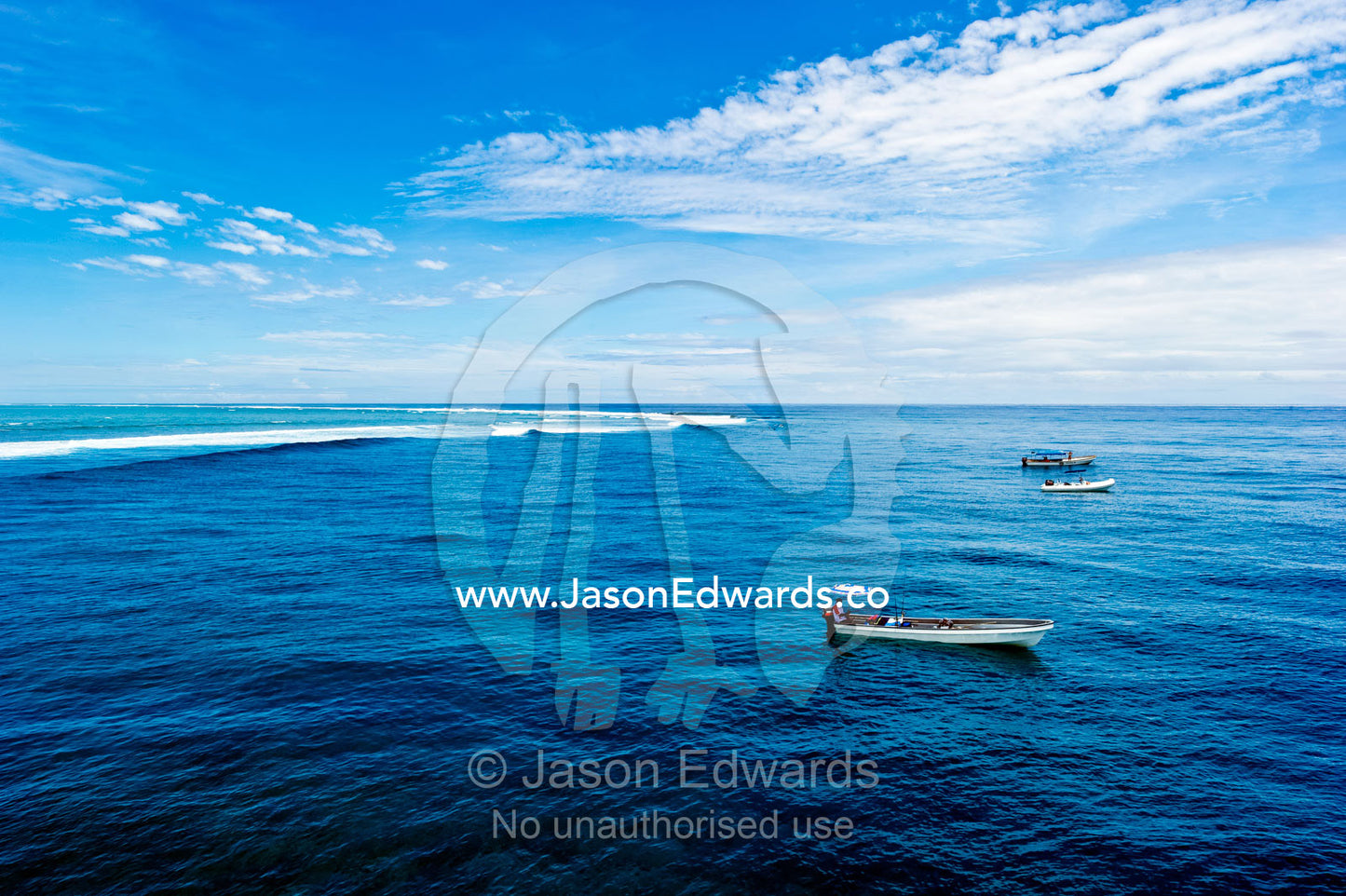 Water taxis wait for surfers at the famous surf reef Cloudbreak. Cloudbreak Reef, Tavarua Island, Pacific Ocean, Fiji Islands.
