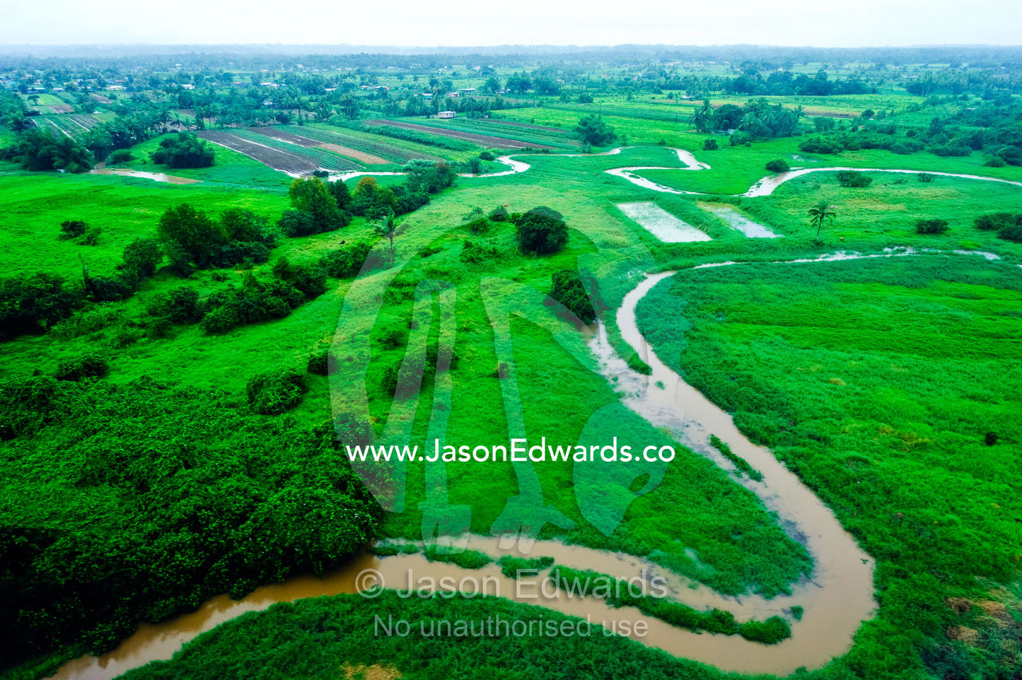 Torrential rain floods roads that wind their way through farm fields. Viti Levu Island, Pacific Ocean, Fiji Islands.