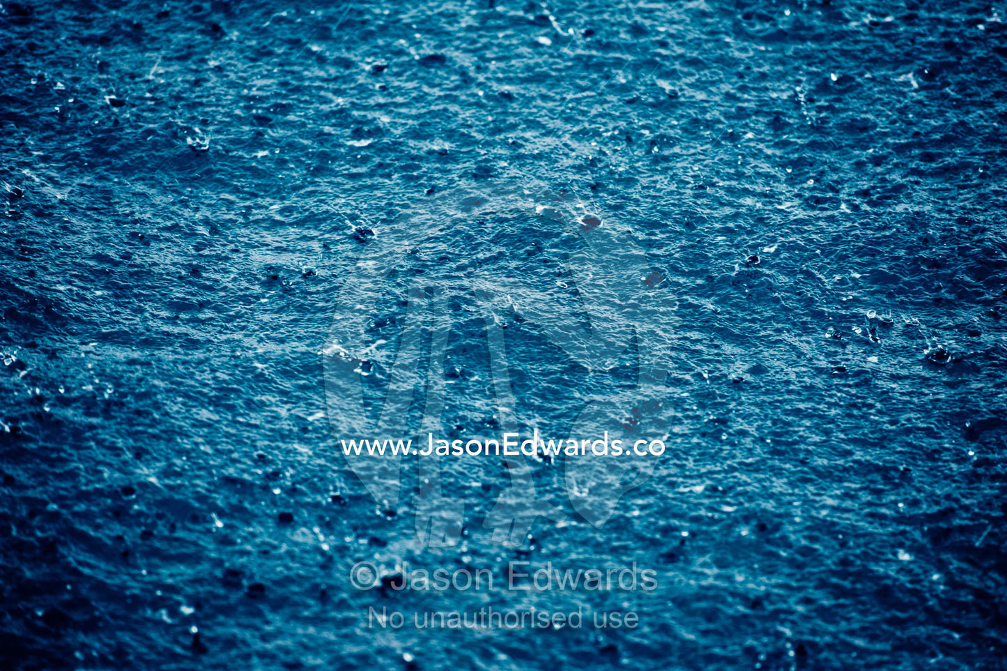 Torrential tropical downpours send raindrops into the ocean surface. Cobia Island, Ringgold Atolls, Pacific Ocean, Fiji Islands.