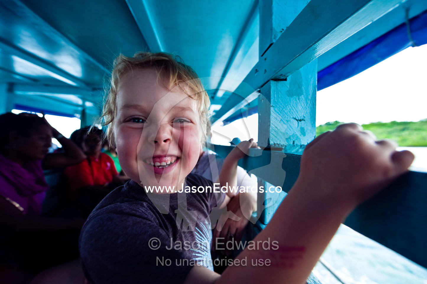 A young tourist catches a water taxi between tropical islands. Natewa Bay, Taveuni Island, Pacific Ocean, Fiji Islands.