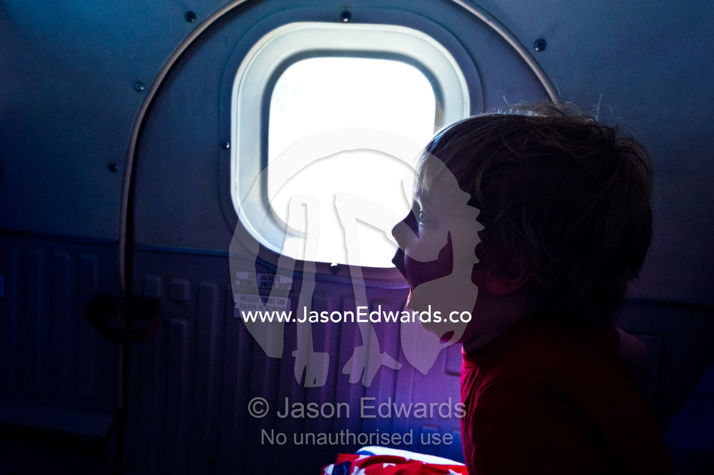 A boy yawns on a light plane travelling between tropical islands. Viti Levu Island, Pacific Ocean, Fiji Islands.