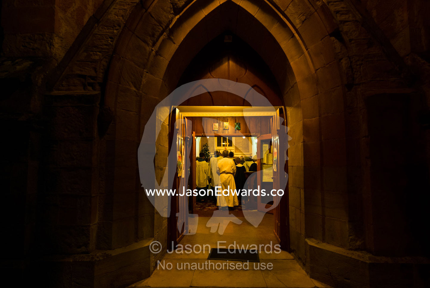 Priest and worshippers inside a church for chorals on Christmas Eve. Christs Church, Castlemaine, Victoria, Australia.