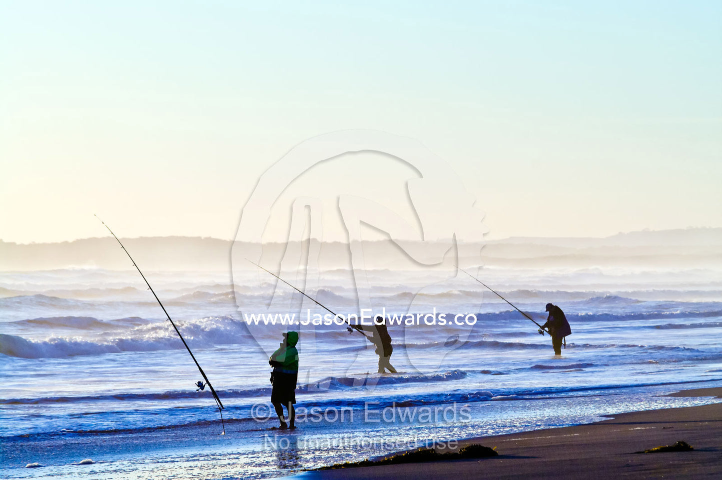 Fishermen try to hook a fish in the waves with long surf fishing rods. Venus Bay, Bass Strait, South Gippsland, Victoria, Australia.
