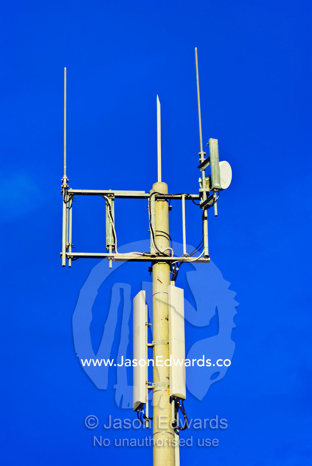 A steel mobile phone tower and receiver rises into a clear blue sky. Melbourne, Victoria, Australia.