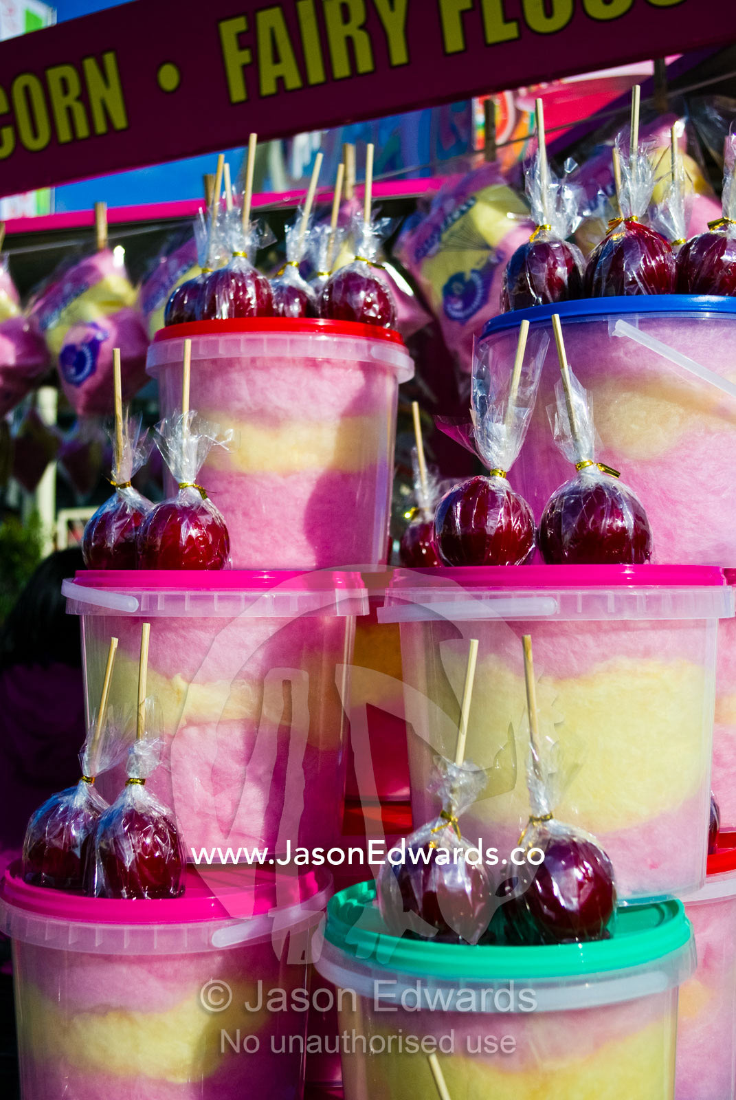 Bright red toffee apples and colourful fairy floss candy for sale. Royal Melbourne Show, Royal Melbourne Agricultural Show, Flemington, Victoria, Australia.