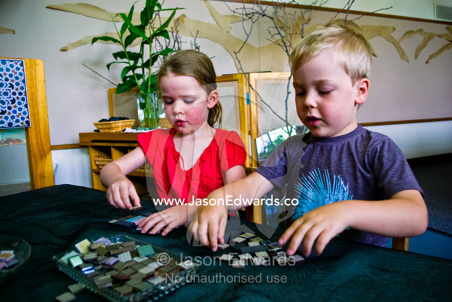 Two friends play with ceramic tiles at their first kindergarden day. University of Melbourne Early Learning Centre, Abbotsford, Collingwood, Melbourne, Victoria, Australia.