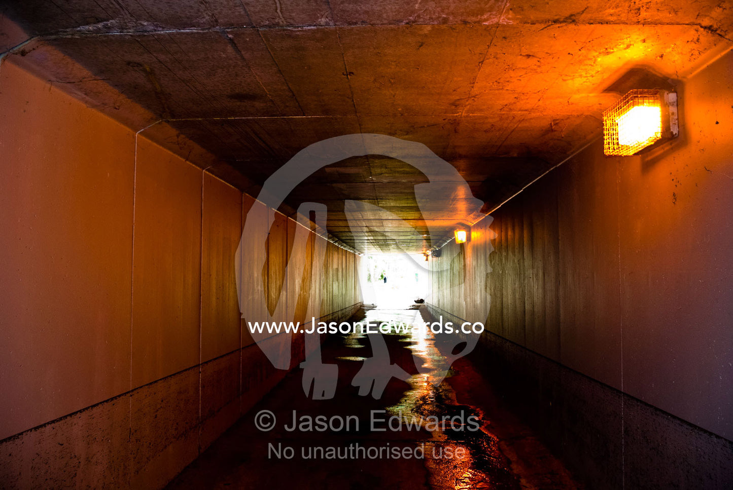 Sunlight at the end of a pedestrian tunnel beneath a freeway overpass. Malvern East, Melbourne, Victoria, Australia.