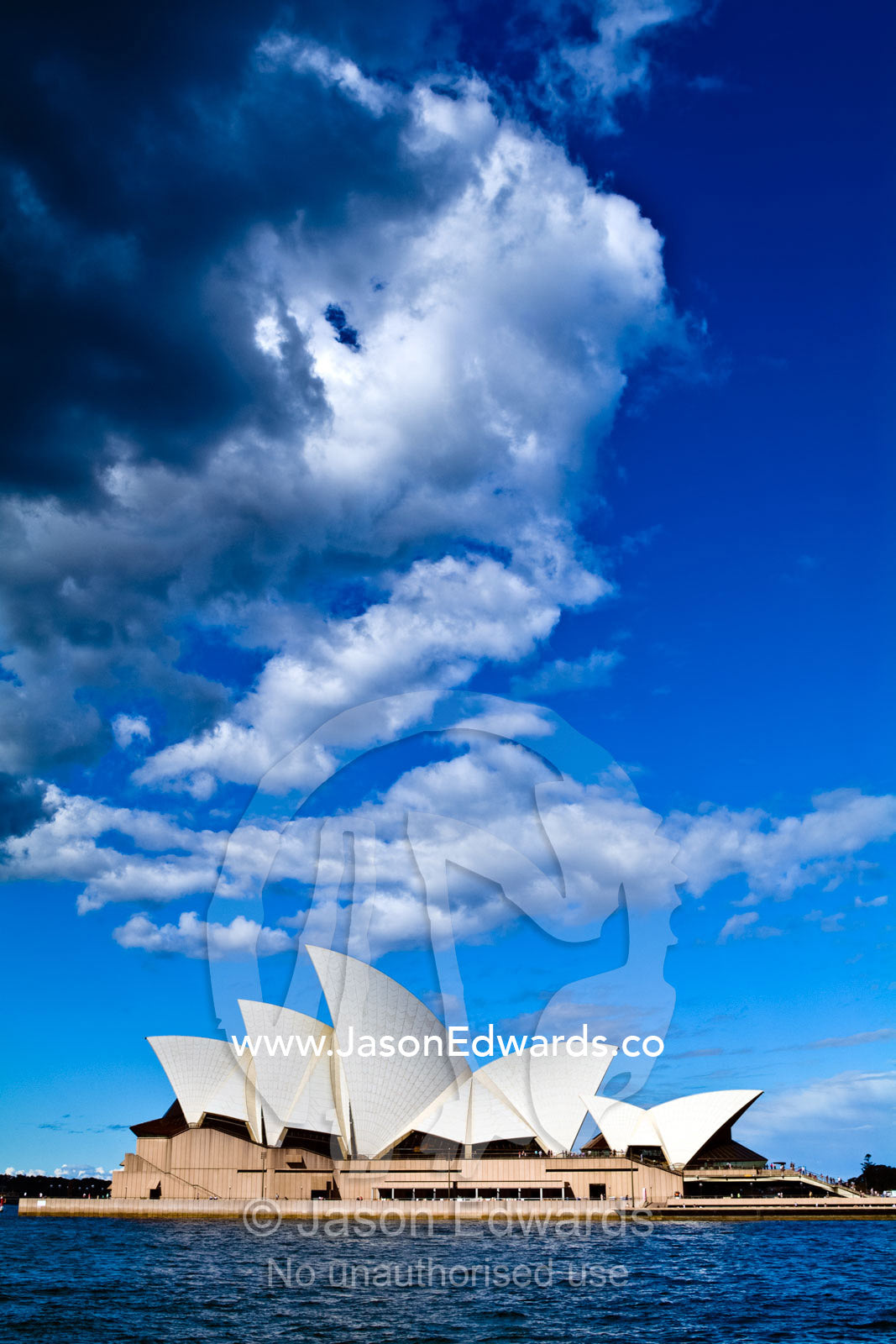 Sails of the Sydney Opera House billow beneath a stormy summer sky. Bennelong Point, Sydney Harbour, Sydney Cove, Warrane, Port Jackson, Circular Quay, Sydney, New South Wales, Australia.