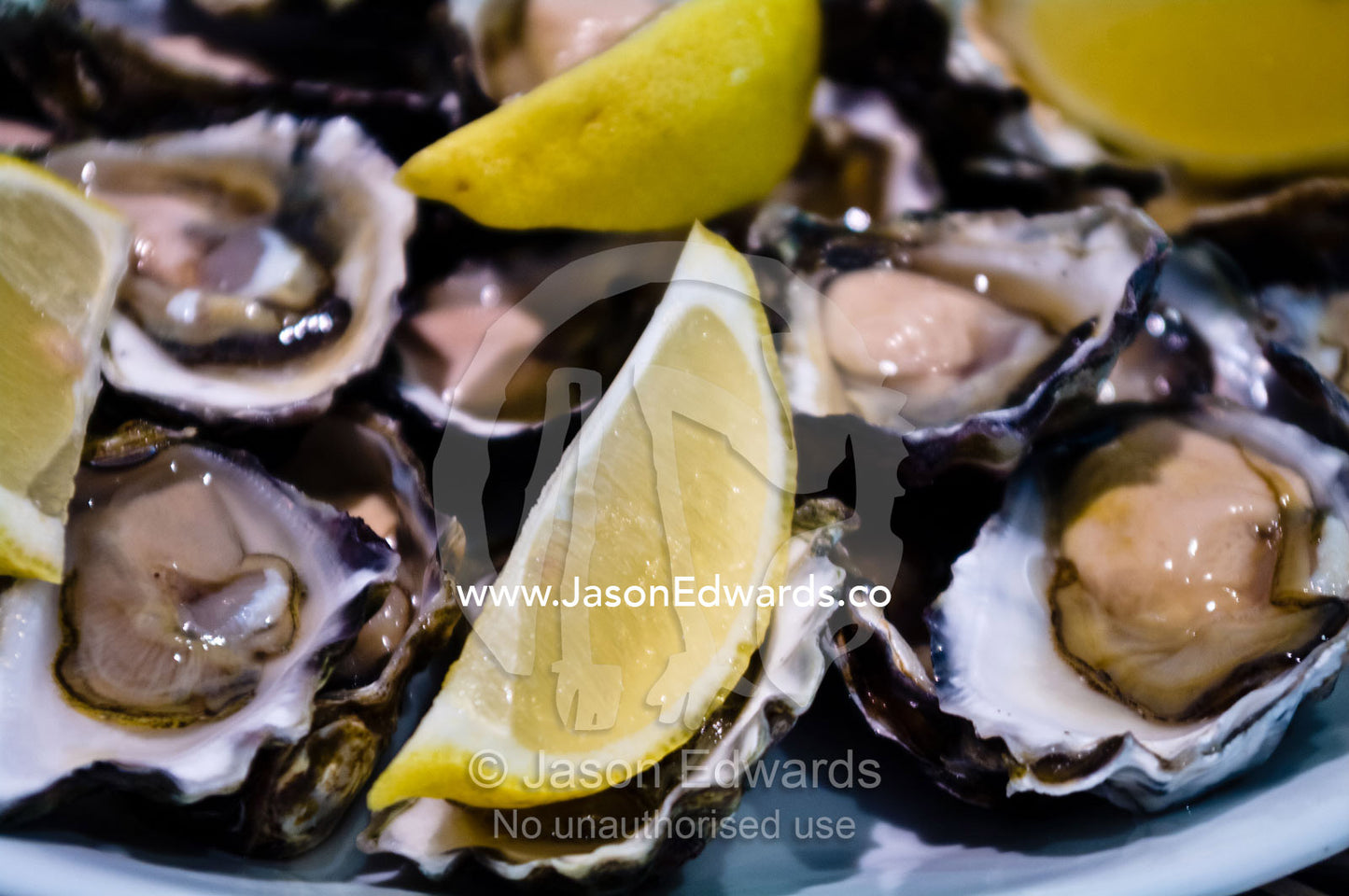 A plate piled high with fresh oysters and lemon for a Chinese lunch. Campsie, Syndey, New South Wales, Australia.