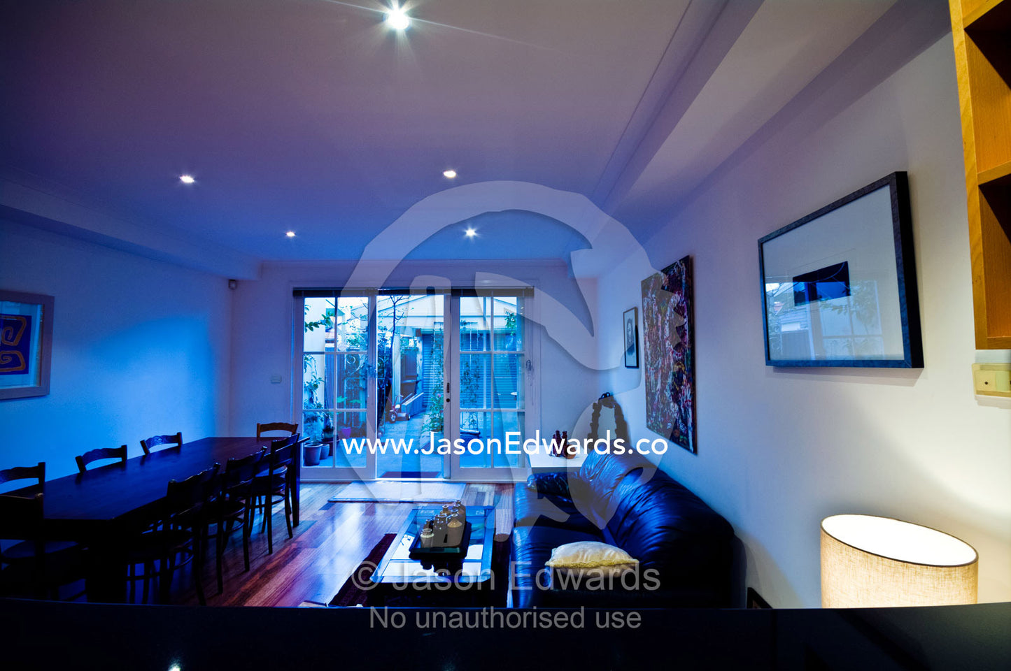 Down lights shine in an open plan living room in a residential house. Brunswick, Melbourne, Victoria, Australia.