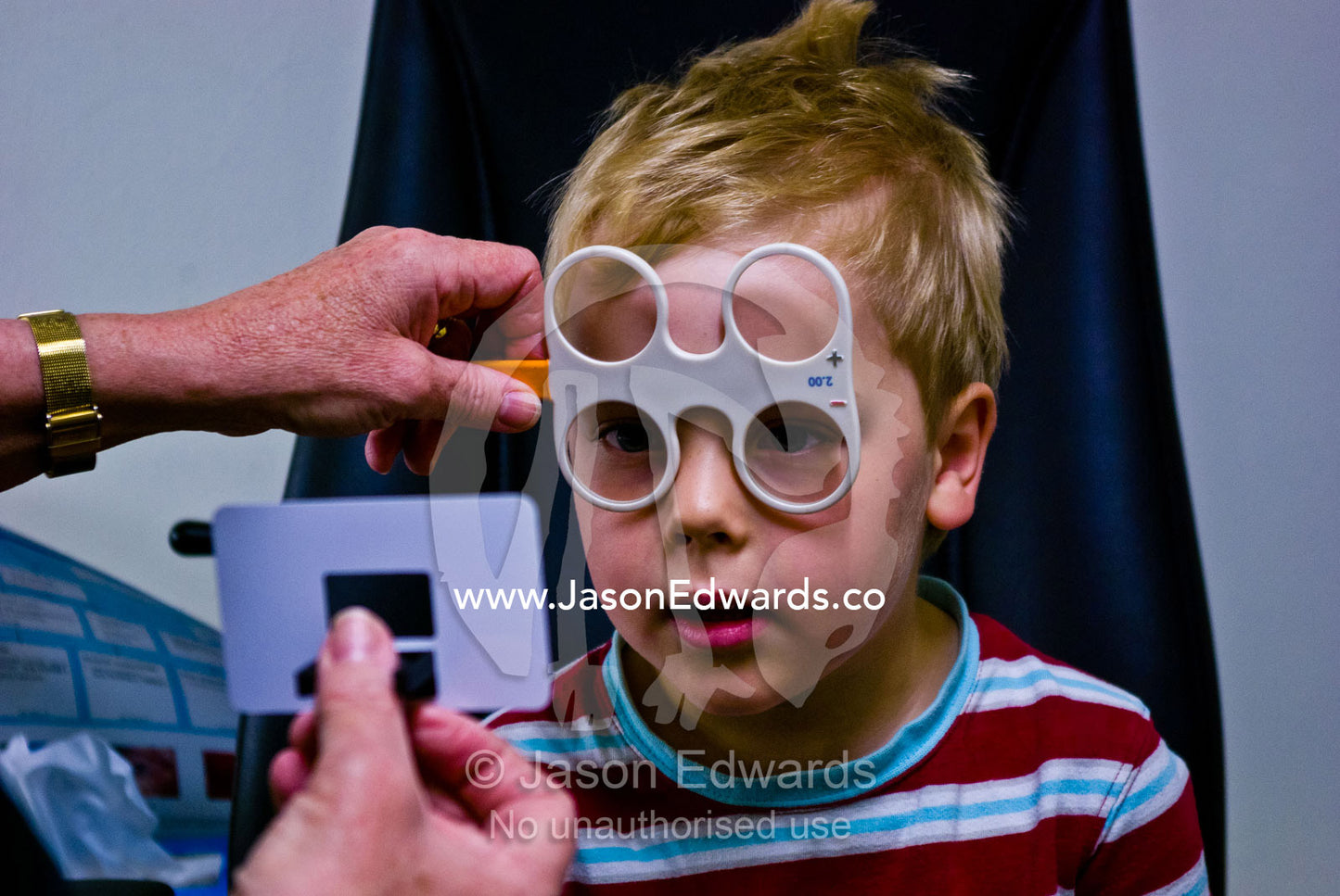 A children's optometrist gives a small boy his first eye examination. Hawthorn, Melbourne, Victoria, Australia.