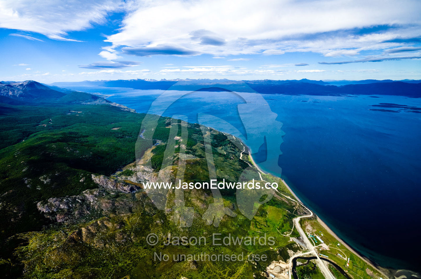 A lone road winds it's way between the Andes and the Beagle Channel. Ushuaia, Martial Mountains, Fuegian Andes, Ushuaia Bay, The Beagle Channel, Tierra del Fuego Archipelago, Straits of Magellan, Tierra del Fuego Province, Patagonia, Argentina.
