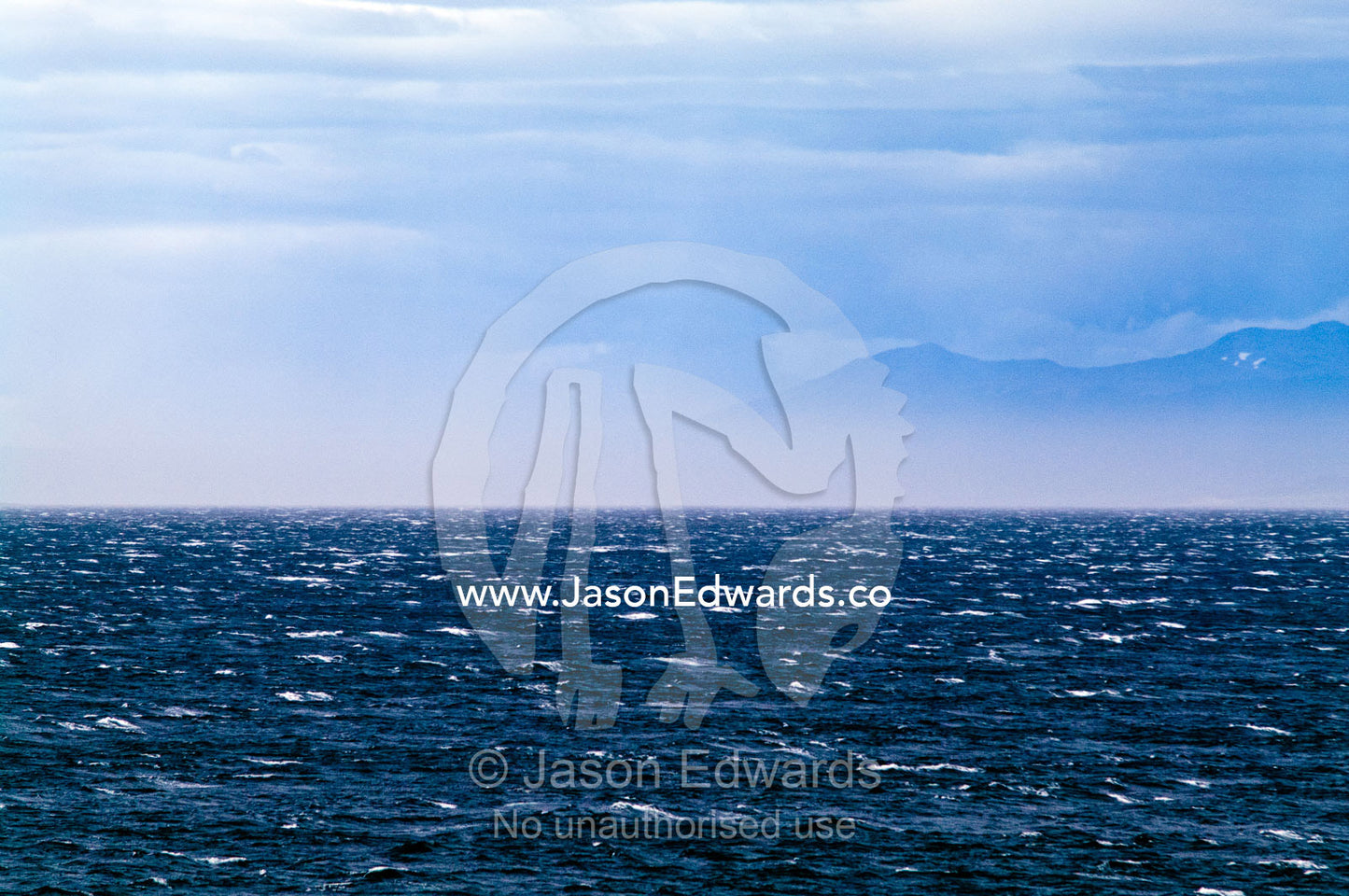 Strong winds whip the ocean surface into a sea of icy whitecaps. Ushuaia, Fuegian Andes, Ushuaia Bay, The Beagle Channel, Tierra del Fuego Archipelago, Straits of Magellan, Tierra del Fuego Province, Patagonia, Argentina.