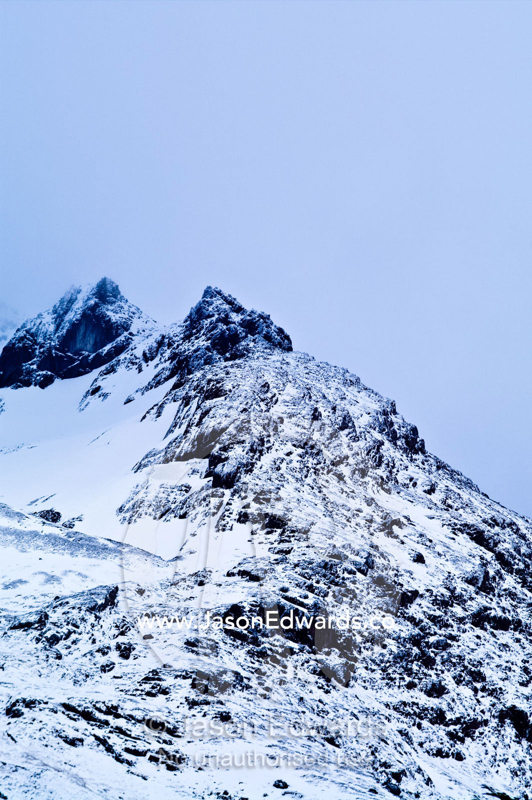 An inhospitable mountain peak in a blizzard covered in snow and ice. Glacier El Martial, Ushuaia, Fuegian Andes, Tierra del Fuego Archipelago, Straits of Magellan, Tierra del Fuego Province, Patagonia, Argentina.