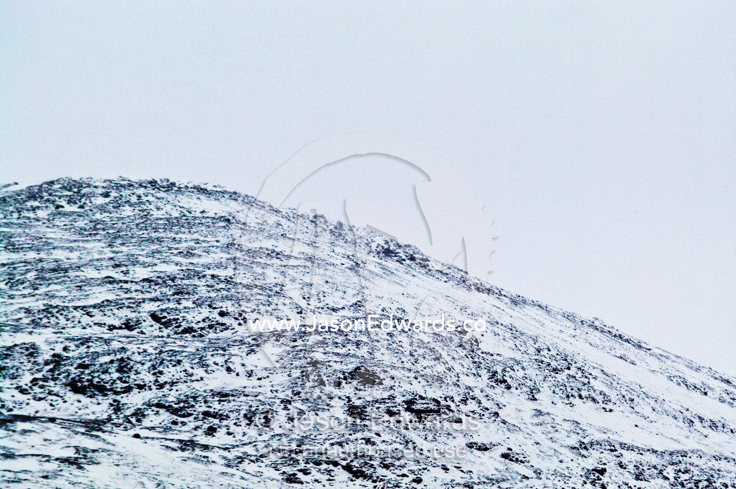 The snowy summit of a dome-shaped hill in a grey blizzard. Glacier El Martial, Ushuaia, Fuegian Andes, Tierra del Fuego Archipelago, Straits of Magellan, Tierra del Fuego Province, Patagonia, Argentina.