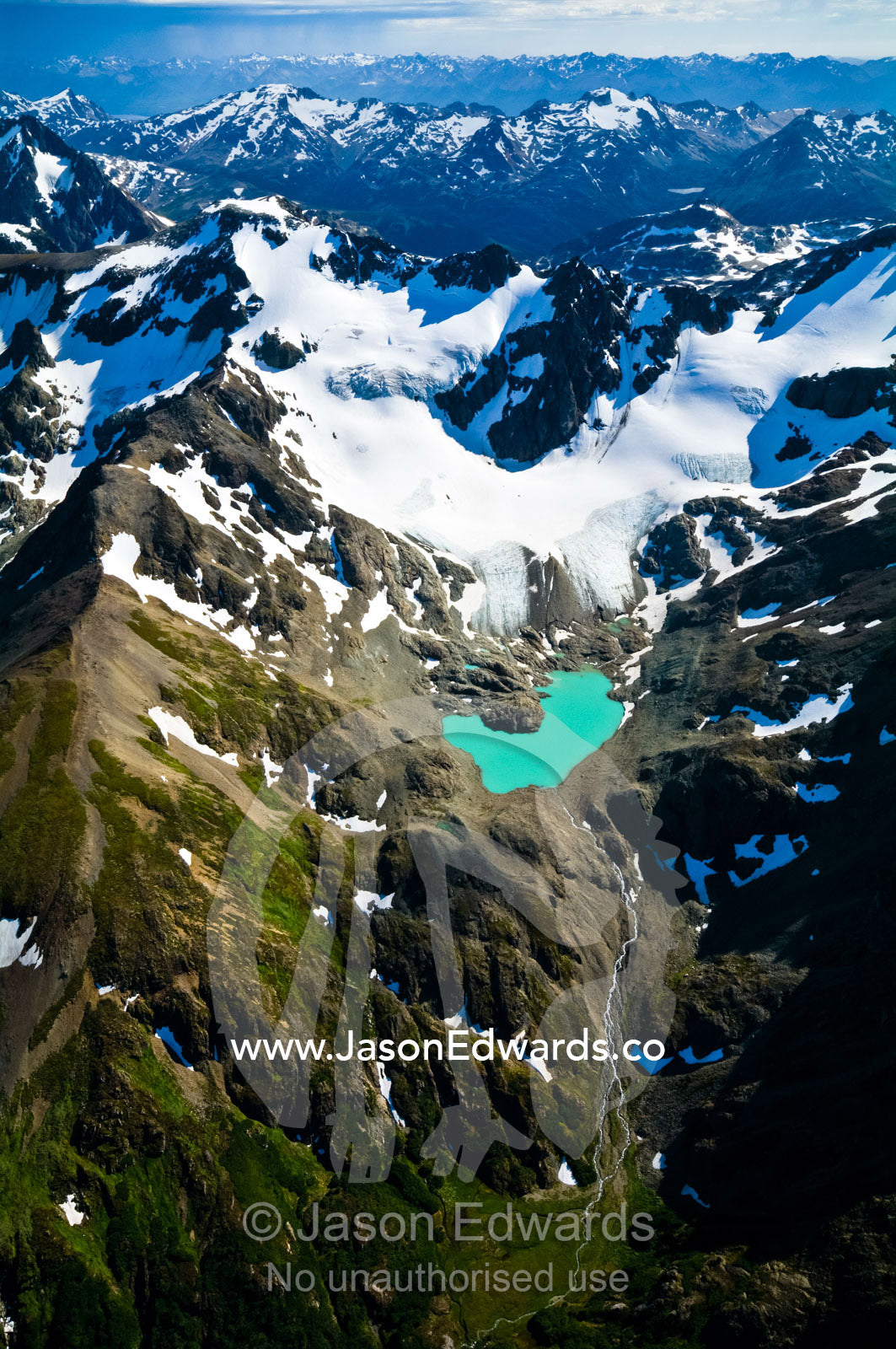 A remote turquoise glacial lake cradled by snow and ice draped peaks. Martial Mountains, Fuegian Andes, Tierra del Fuego Archipelago, Strait of Magellan, Tierra del Fuego Province, Patagonia, Argentina.
