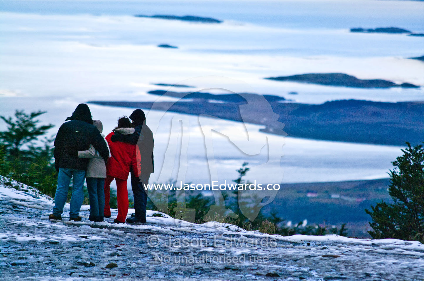 A family admires the view of the Beagle Channel from a mountaintop. Glacier El Martial, Ushuaia, Fuegian Andes, Ushuaia Bay, Beagle Channel, Tierra del Fuego Archipelago, Straits of Magellan, Tierra del Fuego Province, Patagonia, Argentina.