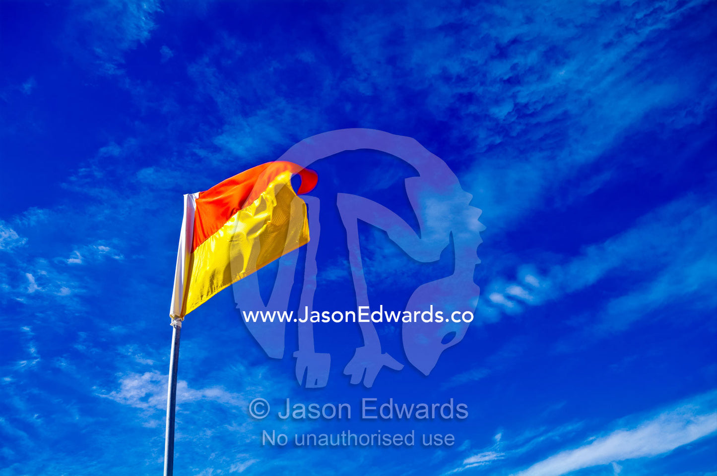 A surf life saving flag on a patrolled beach where it's safe to swim. Venus Bay, Cape Liptrap Coastal Park, Bass Strait, South Gippsland, Victoria, Australia.