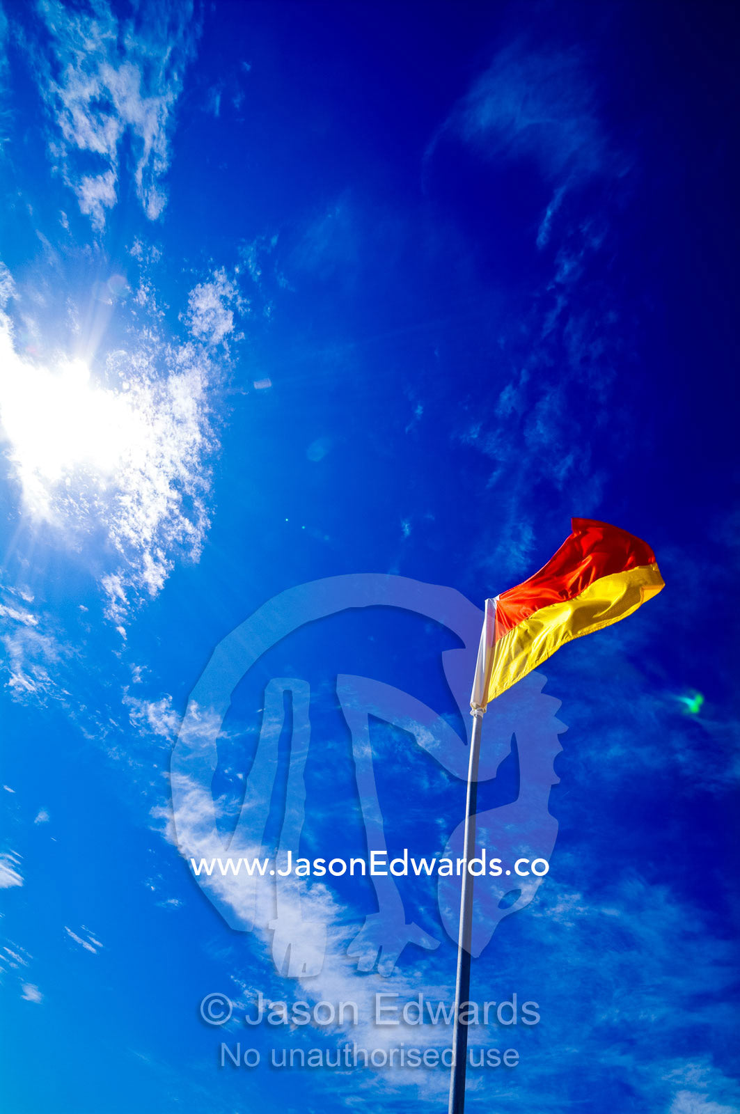 A surf life saving flag on a patrolled beach where it's safe to swim. Venus Bay, Cape Liptrap Coastal Park, Bass Strait, South Gippsland, Victoria, Australia.