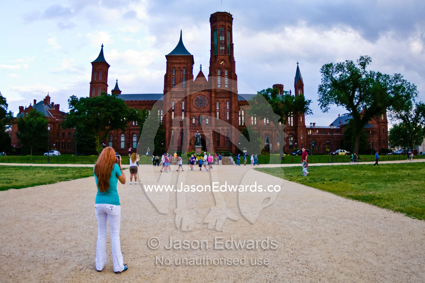 A tourist photographs the facade of the The Smithsonian Castle. The Smithsonian Castle, National Mall, Washington, District of Columbia, United States of America.