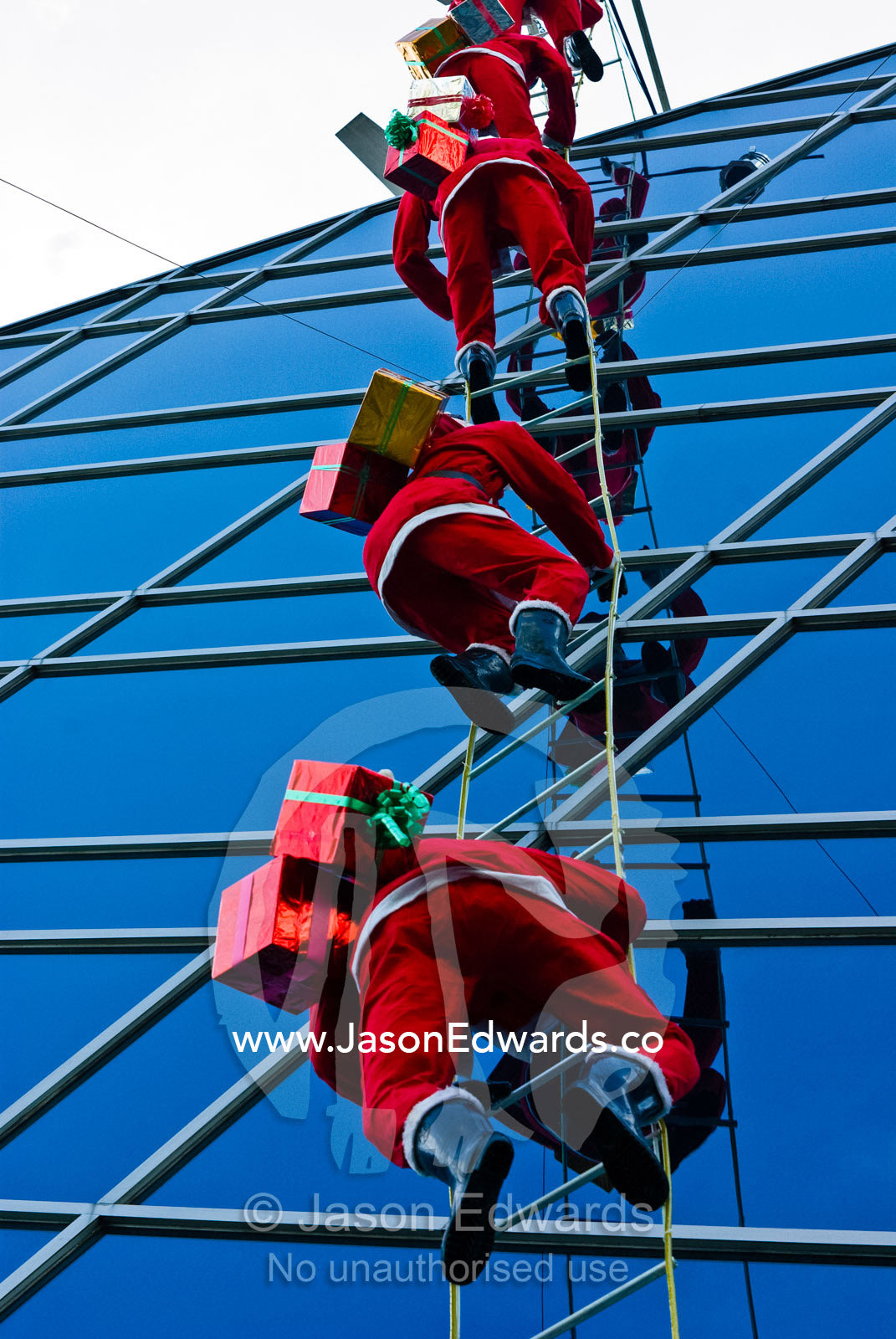 Santa Claus mannequins climbing the outside of a shopping mall. MBK Centre, Mahboonkrong Shopping Center, Bangkok, Thailand.