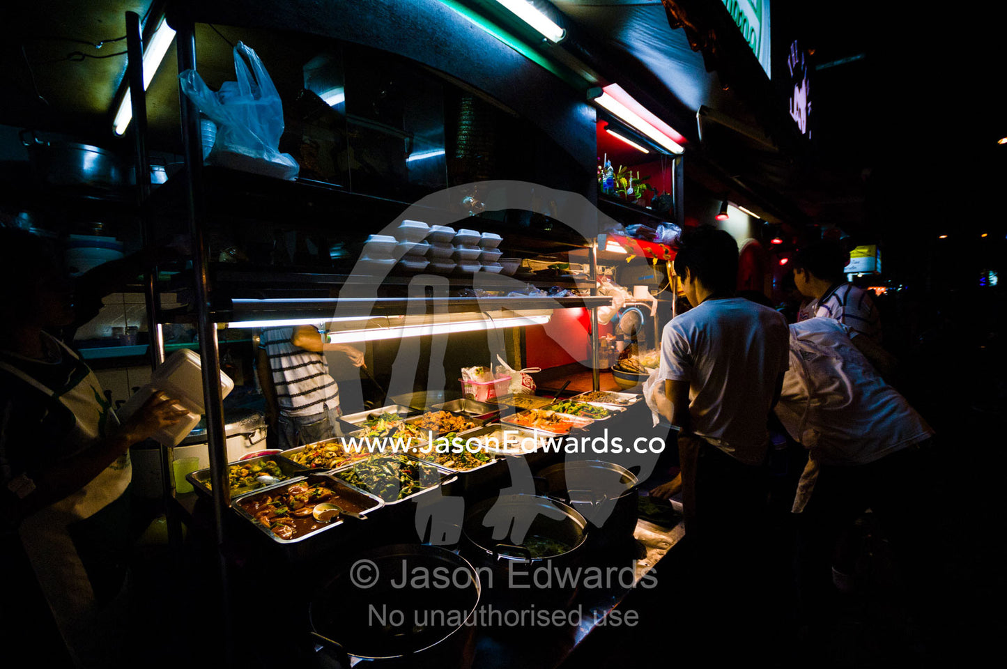 Dinner patrons browse take-away noodles and spicy curry dishes to eat. MBK Centre, Mahboonkrong Shopping Center, Bangkok, Thailand.