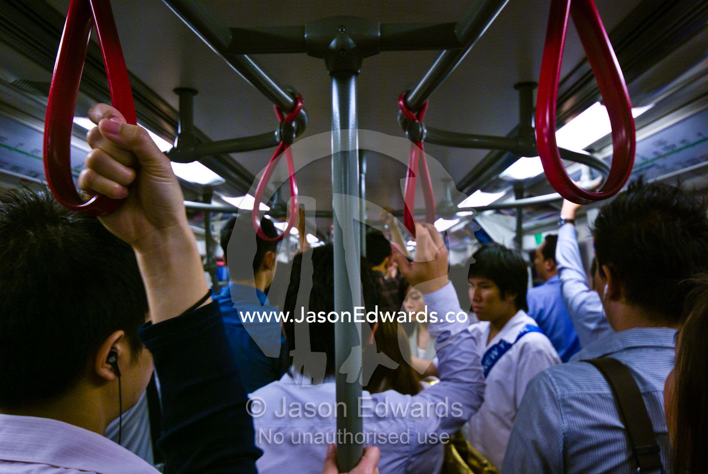 Rush hour office commuters on a crowded city train in Bangkok. Bangkok, Thailand.